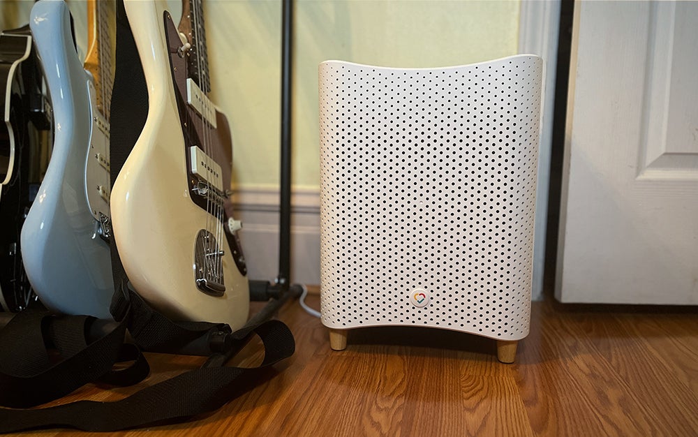 A Mila air purifier next to guitars right by a doorway
